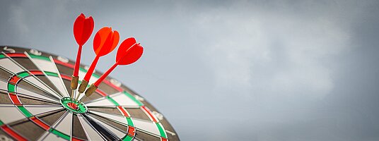 Dartscheibe mit 3 Darts im Zentrum